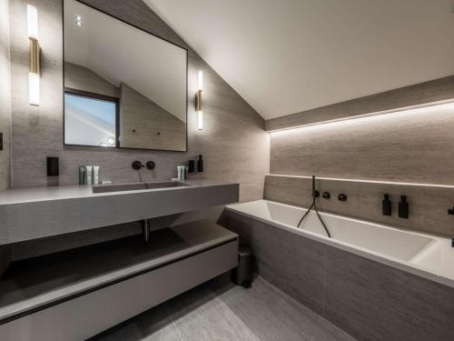 谷雪维尔Appartement ski aux pieds à Courchevel avec cheminée, parking, Wi-Fi pour 9 personnes - FR-1-631-222的带浴缸、水槽和镜子的浴室