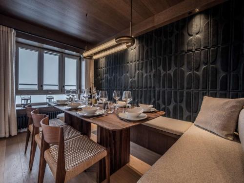 une salle à manger avec une table et des verres à vin dans l'établissement Appartement ski aux pieds à Courchevel avec cheminée, parking, Wi-Fi pour 9 personnes - FR-1-631-222, à Courchevel
