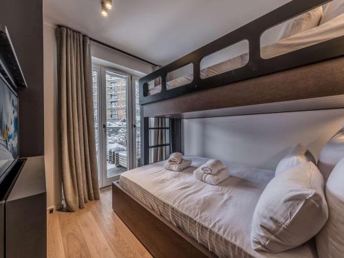 谷雪维尔Appartement ski aux pieds à Courchevel avec cheminée, parking, Wi-Fi pour 9 personnes - FR-1-631-222的一间卧室配有双层床和2条毛巾