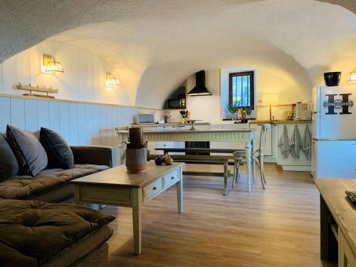 une cuisine et un salon avec un canapé et une table dans l'établissement Charmante maison en pierres avec jardin, WiFi, pour 6 personnes - Sud Ardèche - FR-1-382-217, à Sampzon