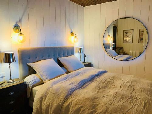 une chambre avec un grand lit et un miroir dans l'établissement Charmante maison en pierres avec jardin, WiFi, pour 6 personnes - Sud Ardèche - FR-1-382-217, à Sampzon