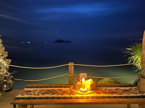 a table with a candle on a balcony at night at Siam Cookies Cottage in Haad Pleayleam