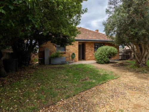 a brick house with a yard in front of it at Retro Retreat in Warrnambool