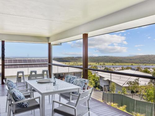 a patio with a table and chairs on a balcony at River View Beach Hub in Maclean