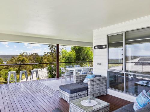 a house with a deck with a table and chairs at River View Beach Hub in Maclean