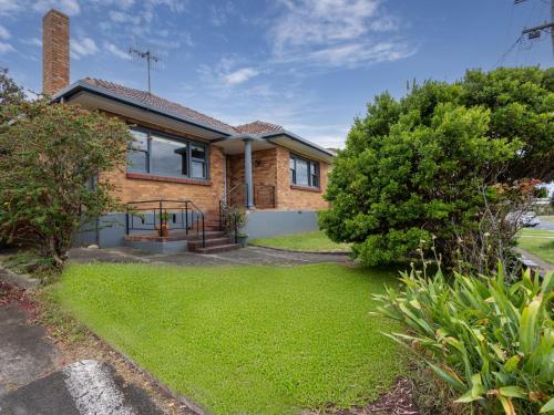a brick house with a lawn in front of it at Retro Retreat in Warrnambool