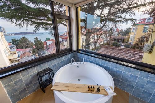 a bath tub in a room with a large window at September Republic of China Residence in Qingdao in Qingdao