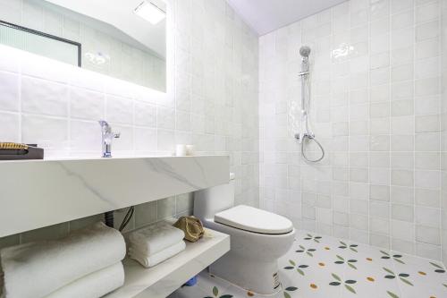 a white bathroom with a sink and a toilet at September Republic of China Residence in Qingdao in Qingdao