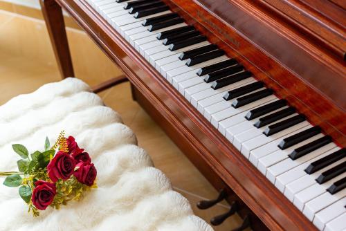 a piano with a bouquet of roses on it at September Republic of China Residence in Qingdao in Qingdao