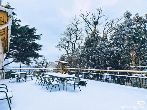 a patio with tables and chairs in the snow at September Republic of China Residence in Qingdao in Qingdao