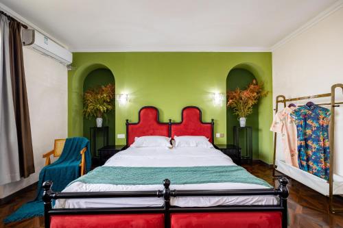 a bedroom with a large bed with green walls at September Republic of China Residence in Qingdao in Qingdao