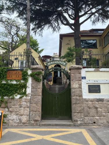 a green gate in front of a house at September Republic of China Residence in Qingdao in Qingdao