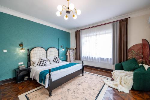 a bedroom with a bed and a couch and a window at September Republic of China Residence in Qingdao in Qingdao