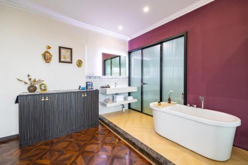 a bathroom with a large tub and a red wall at September Republic of China Residence in Qingdao in Qingdao
