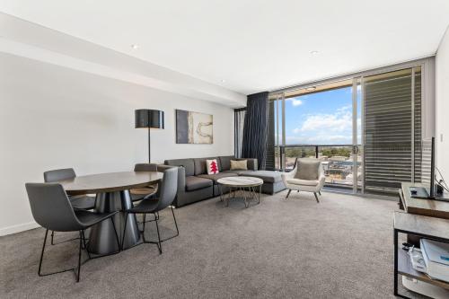 a living room with a couch and a table at One Bedroom Private Apartment at 88 Archer St Chatswood in Sydney