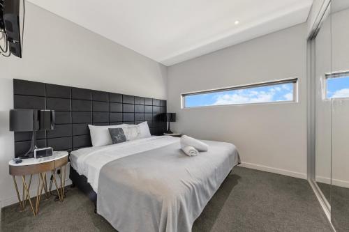 a bedroom with a large bed and a window at One Bedroom Private Apartment at 88 Archer St Chatswood in Sydney