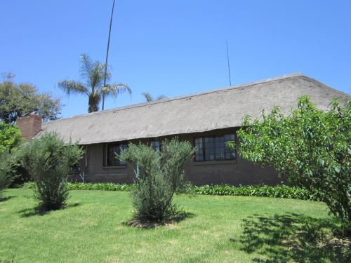 a house with trees in front of it at Owls Loft Guest House in Midrand