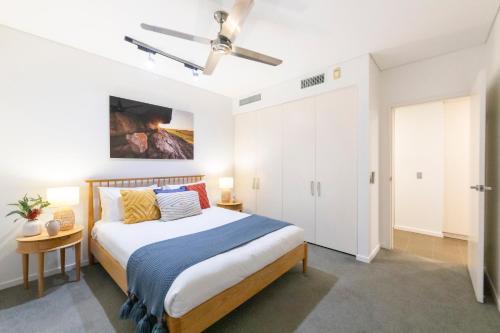 a bedroom with a bed and a ceiling fan at Waterfront Bliss - Explore Darwin's Premier Location in Darwin