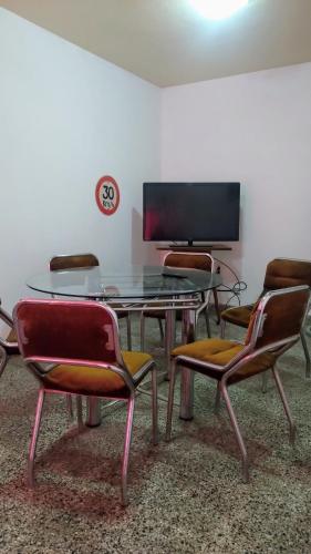 a room with a table and chairs and a tv at Casa hasta 5 personas in Villa Carlos Paz