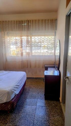 a bedroom with a bed and a window and a table at Casa hasta 5 personas in Villa Carlos Paz