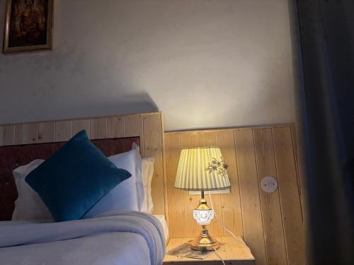 a bedroom with a bed with a lamp on a table at Urban wave 2Bed rooms by Vanasthali in Kasauli