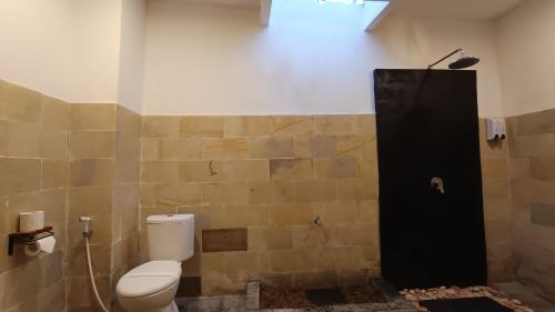 a bathroom with a toilet and a black shower at Villa Nusa Summerville in Gili Trawangan