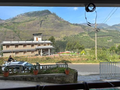 a person riding a bike in front of a building at Mountain Breeze Resort Vattavada in Munnar