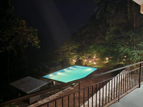 an outdoor swimming pool at night with lights at Diga vista resorts in Palakkad