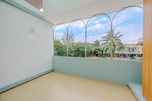 an empty room with a window and palm trees at Bania 813 House in Khao Lak