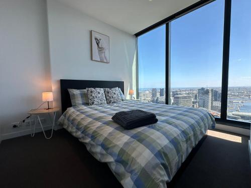a bedroom with a bed and a large window at Top-Floor Luxury 1B1B apt L44 with Spectacular City Views in Melbourne