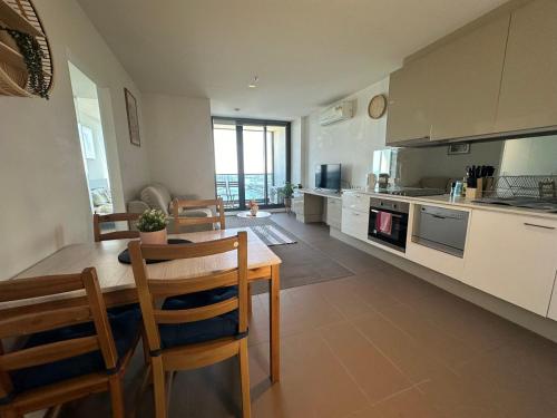 a kitchen and dining room with a table and chairs at Top-Floor Luxury 1B1B apt L44 with Spectacular City Views in Melbourne