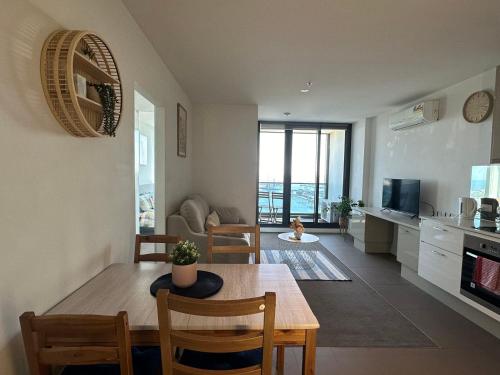 a kitchen and living room with a table and chairs at Top-Floor Luxury 1B1B apt L44 with Spectacular City Views in Melbourne