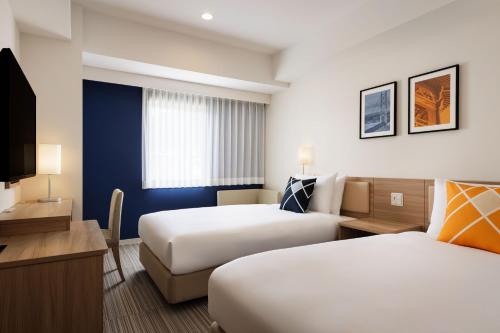 Postel nebo postele na pokoji v ubytování Four Points Flex by Sheraton Kobe Sannomiya