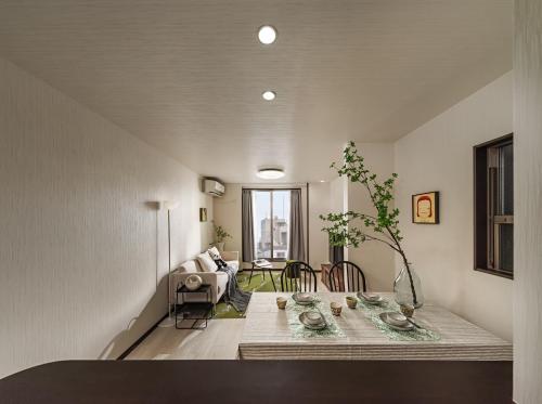 a living room with a table and a couch at 福助安可105sqm Teradacho 5mins JR Loop near Tenojii Shinsaibashi Namba USJ Direct in Osaka