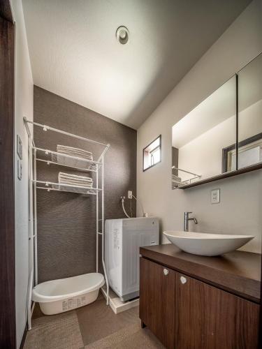 a bathroom with a sink and a toilet and a mirror at 福助安可105sqm Teradacho 5mins JR Loop near Tenojii Shinsaibashi Namba USJ Direct in Osaka