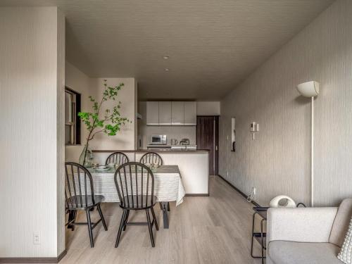 a kitchen and living room with a table and chairs at 福助安可105sqm Teradacho 5mins JR Loop near Tenojii Shinsaibashi Namba USJ Direct in Osaka