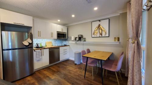 a small kitchen with a table and a refrigerator at Airdrie Modern Walkout Bsmt Suite with Hot Tub in Airdrie