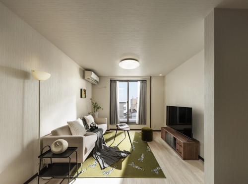 a living room with a couch and a tv at 福助安可105sqm Teradacho 5mins JR Loop near Tenojii Shinsaibashi Namba USJ Direct in Osaka