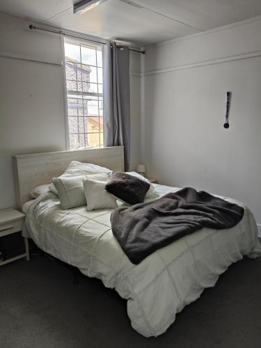 sypialnia z dużym łóżkiem i dużym oknem w obiekcie Apartment In Nelson CBD Hospitality Zone w mieście Nelson