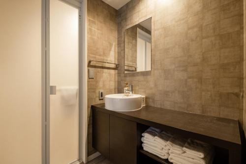 a bathroom with a sink and a mirror at GRAND BASE Moji Nagomi in Kitakyushu
