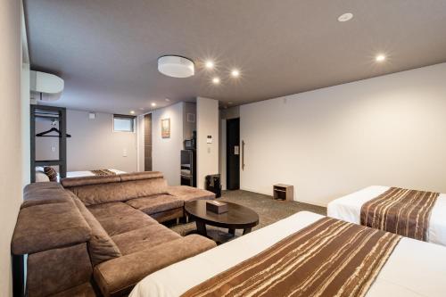 a living room with a couch and two beds at GRAND BASE Moji Nagomi in Kitakyushu