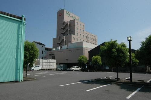 an empty parking lot with a large building in the background at Hotel Green Park Suzuka in Suzuka