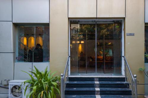a staircase leading to a building with glass doors at Alaya Stays Hotel Emperor Palms in New Delhi