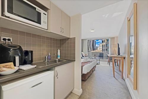 a kitchen with a sink and a living room at Serain Chatswood Central in Sydney