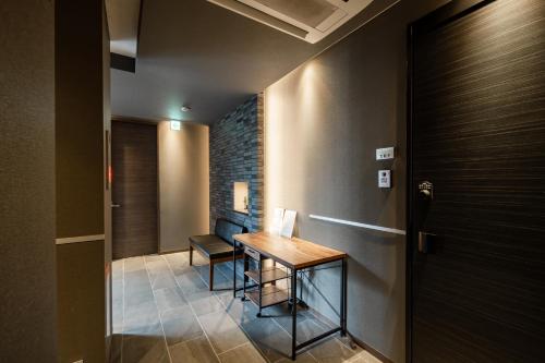 a hallway with a wooden table and a door at GRAND BASE Moji Nagomi in Kitakyushu