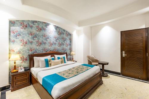 a bedroom with a bed and a floral wall at Alaya Stays Hotel Emperor Palms in New Delhi
