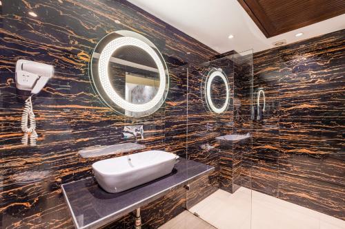 a bathroom with a sink and a mirror at Alaya Stays Hotel Emperor Palms in New Delhi