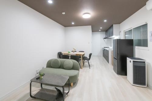 a living room with a table and a chair and a kitchen at 住舎桜ノ宮 in Osaka
