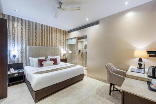 a hotel room with a bed and a bathroom at Alaya Stays Hotel Emperor Palms in New Delhi