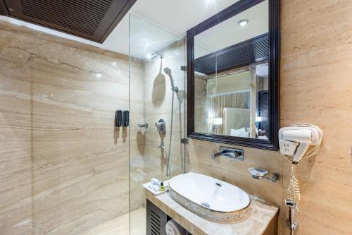 a bathroom with a sink and a shower at Alaya Stays Hotel Emperor Palms in New Delhi